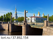Saint Petersburg. Place of the Seven Bridges. View from the Pikalov Bridge Embankment on the Nikolsky Naval Cathedral Belltower on a spring day  (Nikolskiy Morskoy Sobor). The name of the bridge Pikalov Bridge is written on a blue index (2018 год). Стоковое фото, фотограф Виктория Катьянова / Фотобанк Лори