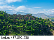 Ruins of houses on a mountainside in Kurib, a depopulated village with the only remaining household with an apiary, Dagestan; another village, Chokh, is visible in the distance. Стоковое фото, фотограф Евгений Харитонов / Фотобанк Лори
