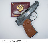 Пистолет на удостоверении с двуглавым орлом - гербом России. Стоковое фото, фотограф Анна Аникова / Фотобанк Лори