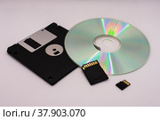 Эволюция памяти. Дискета, CD-диск и карты памяти SD на светлом фоне крупным планом. Стоковое фото, фотограф Анна Аникова / Фотобанк Лори
