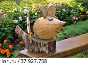 Wooden mouse on wooden bench near flower bed (2020 год). Редакционное фото, фотограф Алексей Антипов / Фотобанк Лори