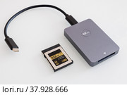 Card reader for cfexpress memory cards on a white background. 512 GB memory card inside (2022 год). Редакционное фото, фотограф Хилько Алексей / Фотобанк Лори