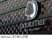 MINSK, BELARUS - December 15, 2017: DoubleTree by Hilton. Logo on facade of the hotel building. Hotel in Minsk, Belarus. Редакционное фото, фотограф Denis Shitikoff / Фотобанк Лори