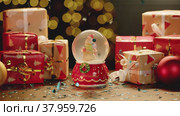 Christmas snowglobe and Christmas gifts on table. Стоковое видео, видеограф Сергей Толмачёв / Фотобанк Лори