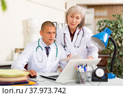 Two physicians working with case histories on laptop in office. Стоковое фото, фотограф Яков Филимонов / Фотобанк Лори