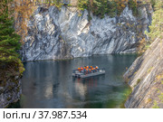 RUSKEALA, RUSSIA - OCTOBER 07, 2021: Excursion on a raft in the marble canyon. Ruskeala, Karelia. Редакционное фото, фотограф Анна Карасева / Фотобанк Лори