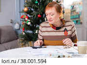 Mature woman calculates utility costs in the new year. Стоковое фото, фотограф Яков Филимонов / Фотобанк Лори