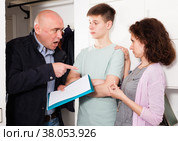 Woman and teen son talking to debt collector. Стоковое фото, фотограф Яков Филимонов / Фотобанк Лори