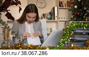 Woman office worker with wage packet in Christmas decorated office. Стоковое видео, видеограф Яков Филимонов / Фотобанк Лори