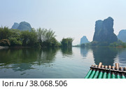 China. Yangshuo. Beautiful unusual tranquil landscape with green karst hills on the Li River. Bamboo tourist raft for a river walk. Natural background (2011 год). Стоковое фото, фотограф Виктория Катьянова / Фотобанк Лори