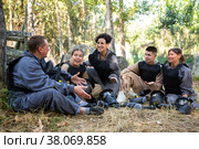 Positive paintball players sitting on battleground and chatting. Стоковое фото, фотограф Яков Филимонов / Фотобанк Лори