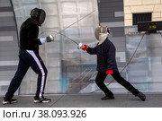 Спортсмен демонстрирует мастер класс фехтования шпаге ребенку на Тверской улице в День города Москвы, Россия (2022 год). Редакционное фото, фотограф Николай Винокуров / Фотобанк Лори
