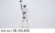 Man in white chemical protection suit holds metal detector. Стоковое видео, видеограф Aleksey Kidisyuk / Фотобанк Лори