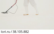 Man in white chemical protection suit holds metal detector. Стоковое видео, видеограф Aleksey Kidisyuk / Фотобанк Лори
