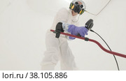 Man in white chemical protection suit holds metal detector. Стоковое видео, видеограф Aleksey Kidisyuk / Фотобанк Лори