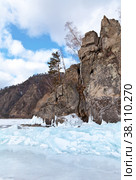 The shore of Lake Baikal near the Circum-Baikal Railway. View of Cape Pillars (Stolby) and blue ice hummocks on a winter day. Стоковое фото, фотограф Виктория Катьянова / Фотобанк Лори