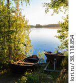 Landscape of the lake with a boat in the foreground. Vertical fr (2015 год). Редакционное фото, фотограф Михаил Аккуратoв / Фотобанк Лори
