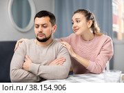 Woman apologizing to offended boyfriend after quarrel at home. Стоковое фото, фотограф Яков Филимонов / Фотобанк Лори