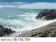 Rocky seashore formed by columnar basalt against the surf, coastal landscape of the Kuril Islands. Стоковое фото, фотограф Евгений Харитонов / Фотобанк Лори
