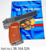 Травматический пистолет крупным планом на брошюре "Федеральный закон РФ "Об оружии" (2022 год). Редакционное фото, фотограф Анна Аникова / Фотобанк Лори