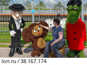 Женщина знакомится с Чебурашкой в сквере у вокзала станции Чудово. Новгородская область (2021 год). Редакционное фото, фотограф Александр Щепин / Фотобанк Лори
