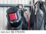 Equipment for gas welding in the workshop: mask, cylinders with a pressure gauge, hoses. Стоковое фото, фотограф Евгений Харитонов / Фотобанк Лори