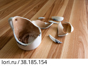 Разбитая белая чашка с осколками на деревянном фоне. Broken white Cup with shards on a wood background. Стоковое фото, фотограф Марина Шабардина / Фотобанк Лори