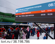 Табло с расписанием и люди встречающие поезд Деда Мороза, центральный вокзал города Воронеж (2022 год). Редакционное фото, фотограф Вячеслав Палес / Фотобанк Лори