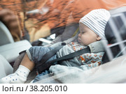 Cute little baby boy sleeping strapped into infant car seat in passenger compartment during car drive. Стоковое фото, фотограф Matej Kastelic / Фотобанк Лори