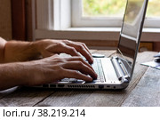 Hands of a man working at a computer laptop by the window. Стоковое фото, фотограф Андрей С / Фотобанк Лори