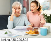 Mother and daughter figuring out finance problem. Стоковое фото, фотограф Яков Филимонов / Фотобанк Лори