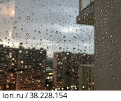 Background drops of water. Raindrop on window panes. Natural pattern of raindrops. Abstract shot of rain drops on glass. Night city and balcony outside window. Selective focus. Space for text or logo. Стоковое фото, фотограф Aleksandr Golubev / Фотобанк Лори