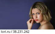 Closeup pretty portrait an angry discontented young woman with finger on lips against dark background. Female shows emotion annoying actress. Concept of adversity and irritation. Copy space for site. Стоковое фото, фотограф Aleksandr Golubev / Фотобанк Лори