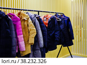 Interior of room storing outdoor clothing for visitors of the establishment, with yellow backgrounds. Wardrobe, many hangers clothes institution, leave outerwear, undress pass into room. Copy space. Стоковое фото, фотограф Aleksandr Golubev / Фотобанк Лори