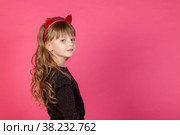 Portrait 6-7 year old girl in black dress on pink isolated background looks at camera. Concept Playing and Children Celebrities. Little child in style clothes posing and showing emotions. Copy space. Стоковое фото, фотограф Aleksandr Golubev / Фотобанк Лори