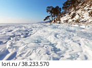 Beautiful winter landscape of frozen Lake Baikal on a sunny day. The lake shore is covered with ice hummocks of transparent snowy ice floes. Winter holidays and ice travel. Natural background. Стоковое фото, фотограф Виктория Катьянова / Фотобанк Лори