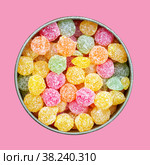 Colorful multicolored sucking sweets Montpensier lollipops in a round tin box isolated on a pink background close-up top view flat lay. Стоковое фото, фотограф Андрей С / Фотобанк Лори