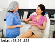 Woman asking cosmetologist about breast lift and reshaping procedures. Стоковое фото, фотограф Яков Филимонов / Фотобанк Лори