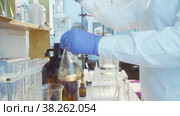 Hands of a scientist titrating solution. Стоковое видео, видеограф Chudakov_Ivan / Фотобанк Лори