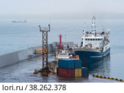 Fishing boat at the pier in the harbor on the shore of a cloudy sea. Стоковое фото, фотограф Евгений Харитонов / Фотобанк Лори
