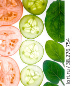 Slices of cucumbers and tomatoes with arugula leaves removed to the light. Стоковое фото, фотограф Ярославский Максим / Фотобанк Лори