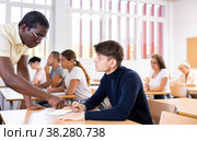 African american teacher prompts an adult student to solve equation. Стоковое фото, фотограф Яков Филимонов / Фотобанк Лори