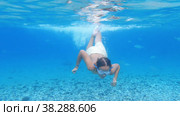 Teenager swims underwater surrounded by fish. Стоковое видео, видеограф Данил Руденко / Фотобанк Лори