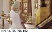 RUSSIA, KAZAN 08-28-2022: the priest conducts baptismal rite for a little girl in the Orthodox Church - walking around the altar in a circle. Редакционное видео, видеограф Константин Шишкин / Фотобанк Лори