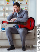 Businessman playing guitar at home. Стоковое фото, фотограф Elnur / Фотобанк Лори