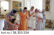 RUSSIA, KAZAN 08-28-2022: family of adult women and a little boy are crossing themselves in the Orthodox Church. Редакционное видео, видеограф Константин Шишкин / Фотобанк Лори