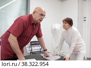 Сергей Михайлович Бубновский тестирует костно-мышечную систему пациентки (2022 год). Редакционное фото, фотограф Дмитрий Неумоин / Фотобанк Лори