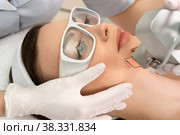 Therapist beautician makes a laser rejuvenation for the model by apparatus in a beauty salon. Стоковое фото, фотограф Юлия Тарасова / Фотобанк Лори