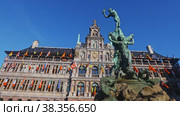 View of Brabo Fountain in front of Antwerp City Hall richly ornamented with heraldic symbols, sculptures and flags Belgium, Flanders and countries of European Union and United Nations on Grote Markt. Стоковое видео, видеограф Яков Филимонов / Фотобанк Лори