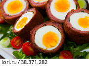 Scotch eggs served with greens and leek, Scottish traditional dish at plate. Стоковое фото, фотограф Яков Филимонов / Фотобанк Лори